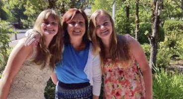 Three blind women smile and pose for a photo together.